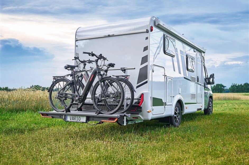 White motorhome on a meadow with SAWIKO VARIO bike carrier on which two bicycles are mounted. | © AL-KO VT